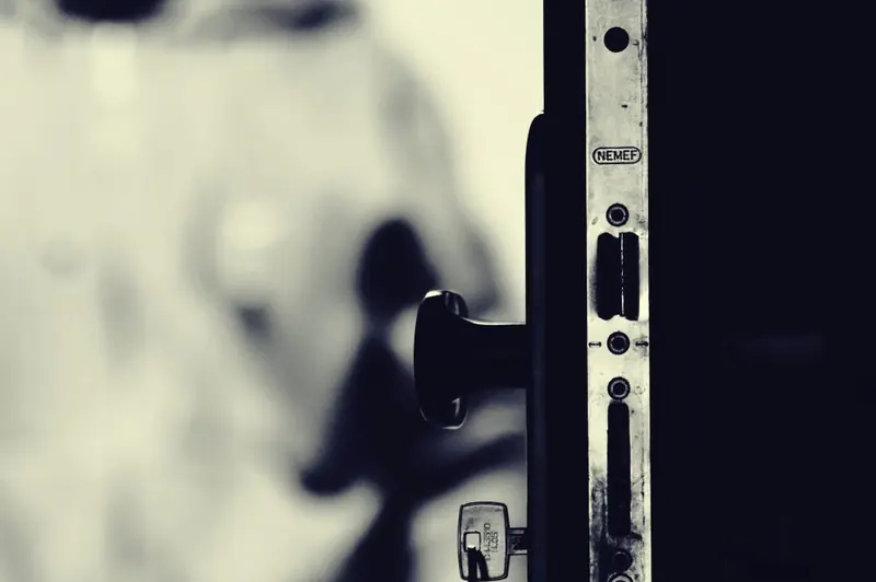 Silhouette floue derrière une porte entrouverte